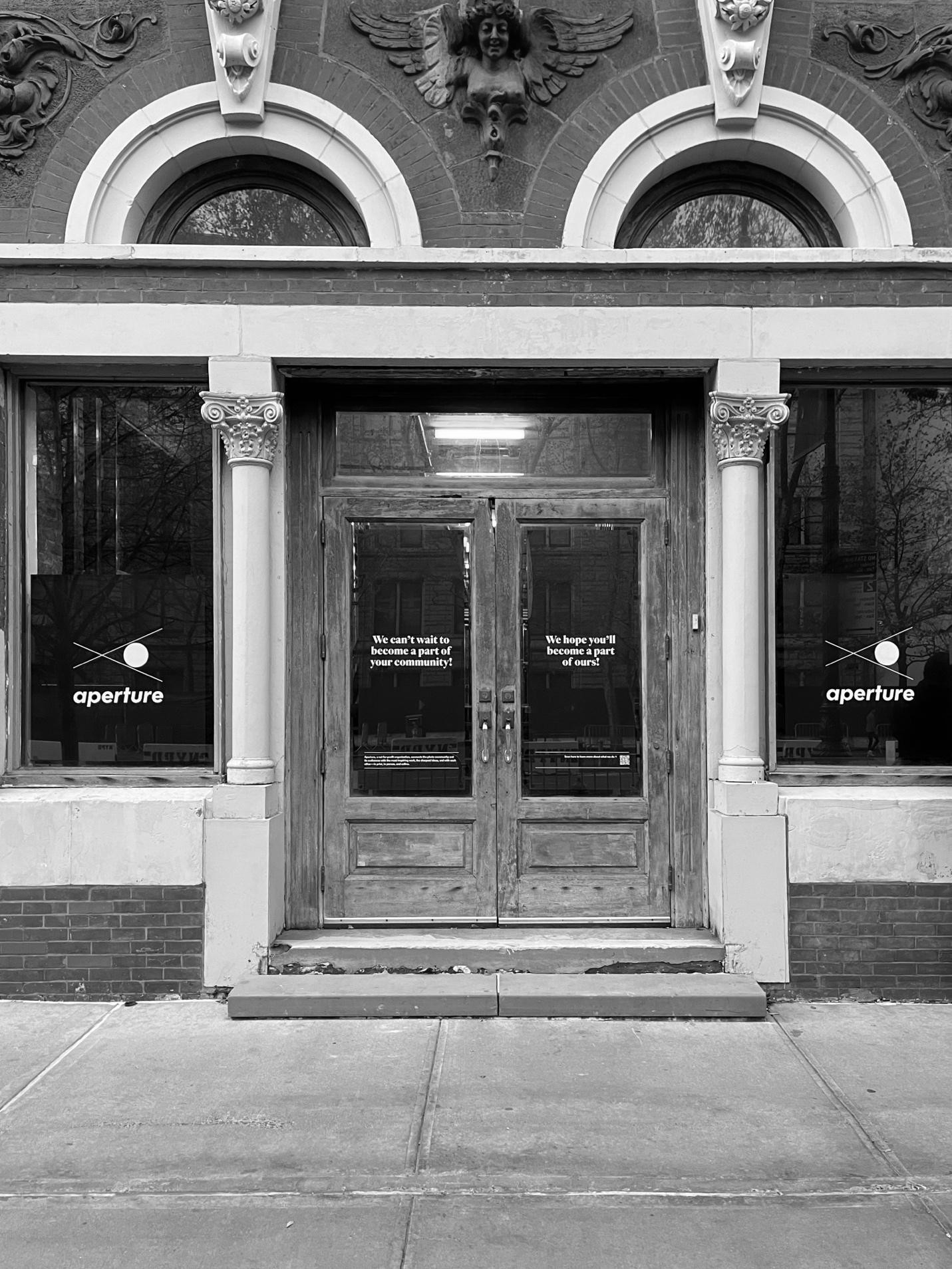 The wooden entrance doors at 380 Columbus Avenue with Aperture signs in the windows