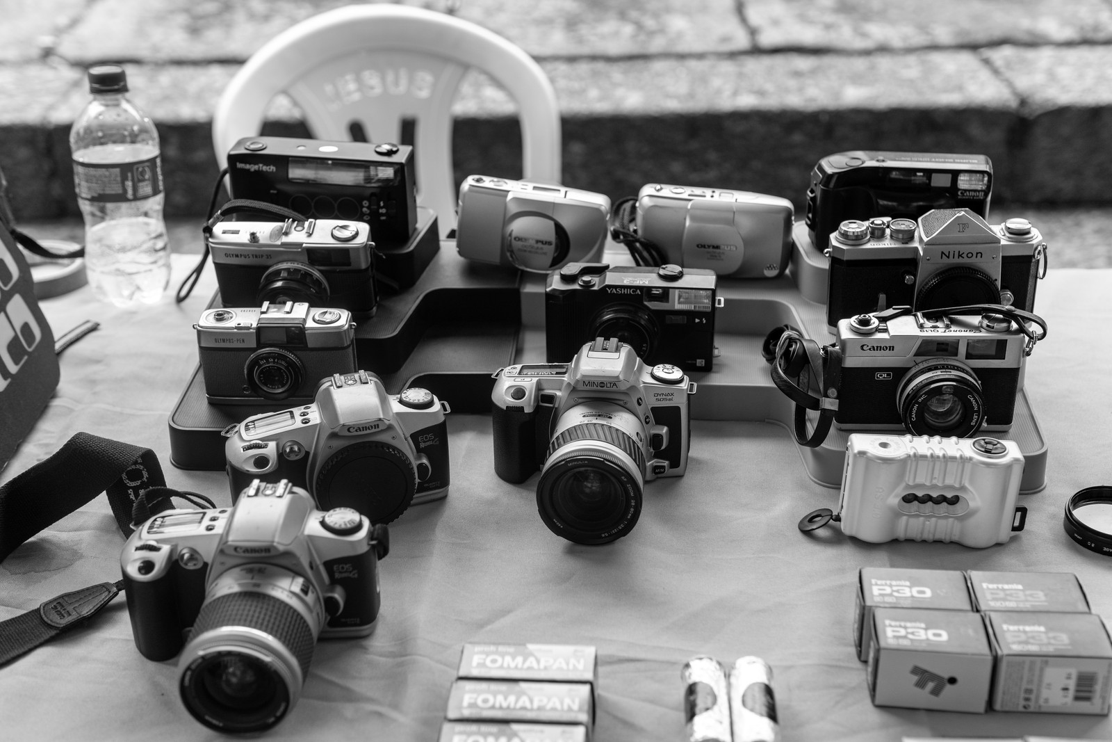 A table covered with film and digital cameras for sale at an outdoor antiques fair