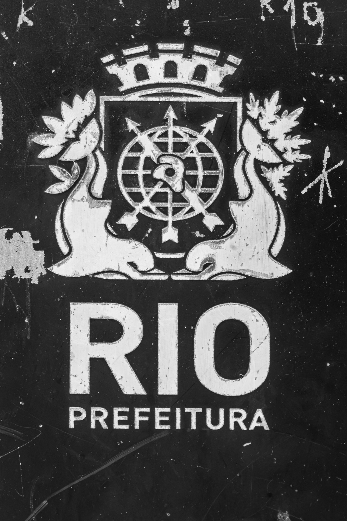 The scratched coat of arms of the city of Rio de Janeiro painted on a dark surface