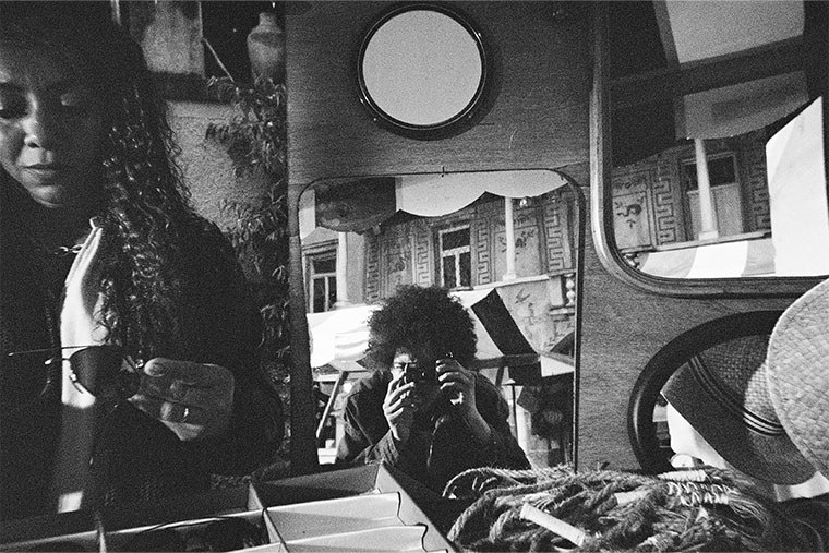 A street scene with a photographer reflected in a round convex mirror, photographed on the QuickSnap Black and White