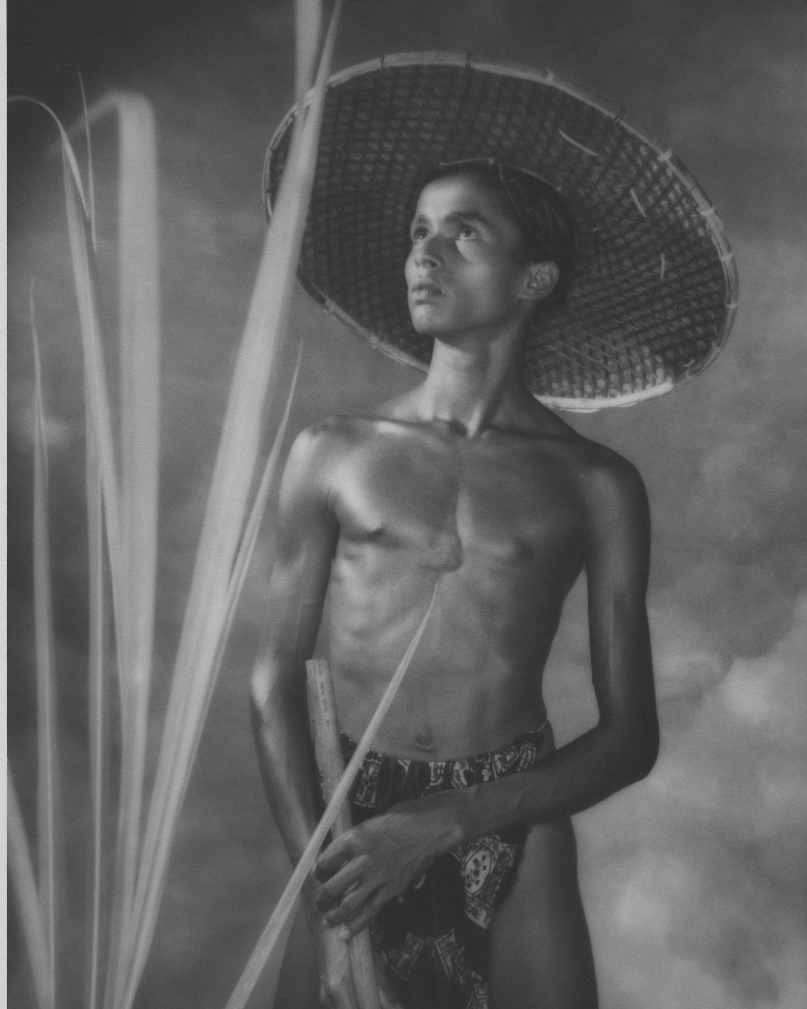 Goviya by Lionel Wendt, a 1937 portrait of a young Sri Lankan farmer in a woven hat, lit from the side against a soft clouded background